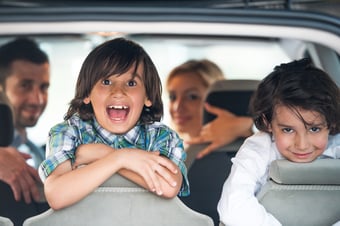 Two cheerful kids on a car backseat